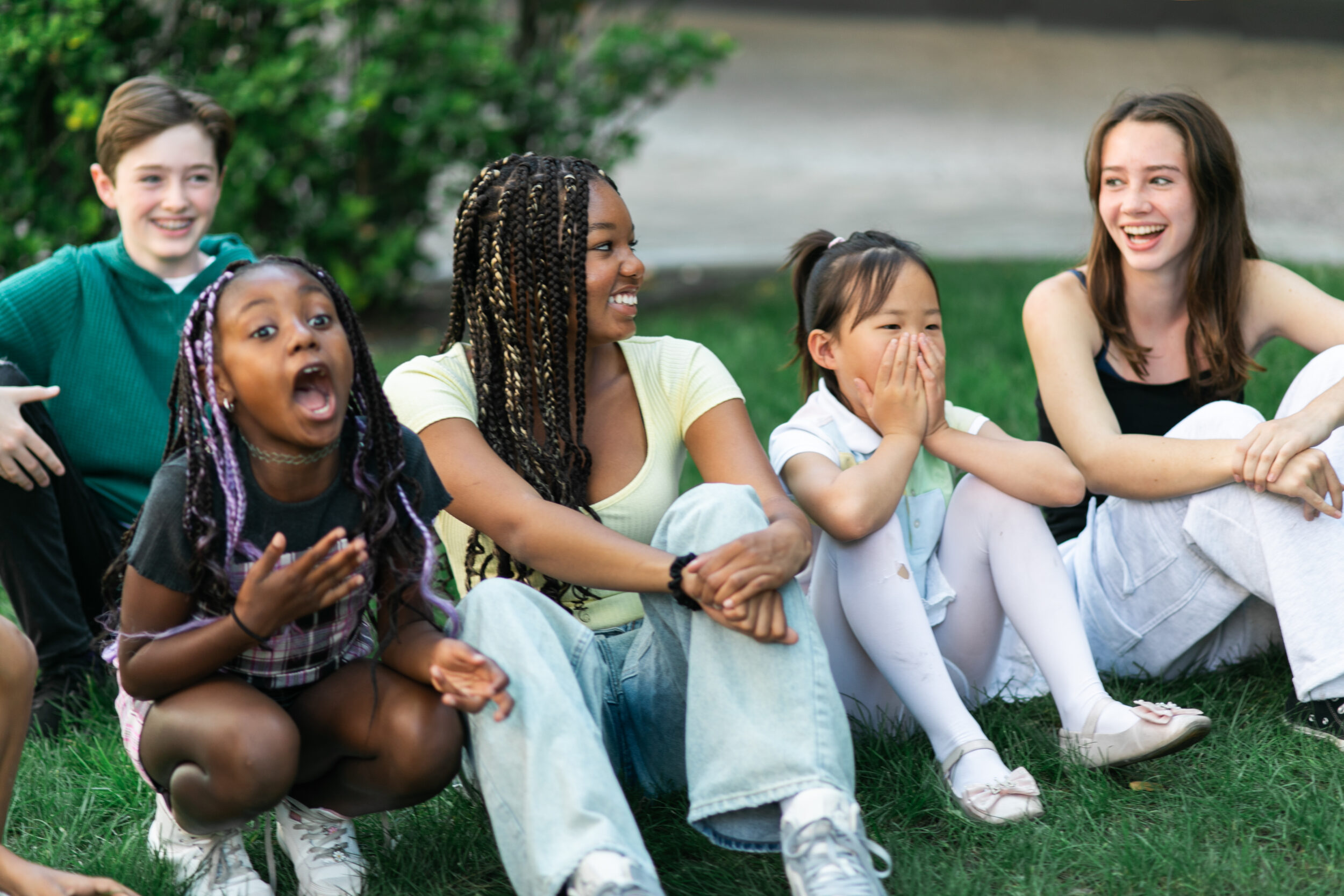 group on children sitting on the grass laughing